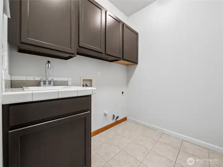 Convenient laundry room designed with a utility sink and plenty of built-in storage. Convenient laundry room designed with a utility sink and plenty of built-in storage.