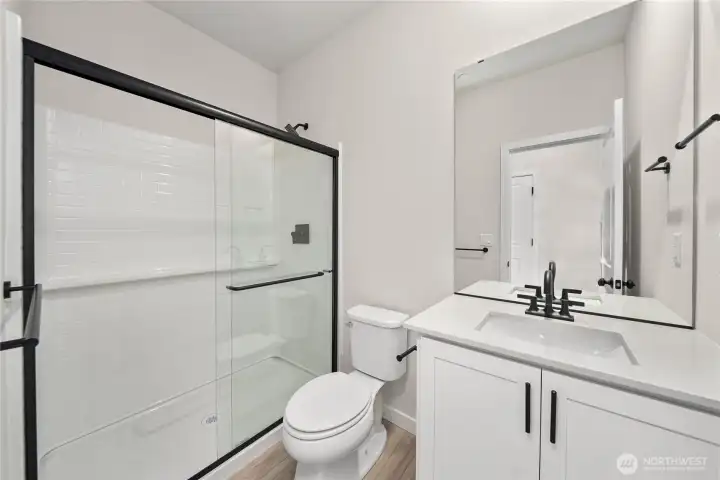 Main level bath. Photos of a previously completed home. Actual colors and finishes may vary. See site agent for details.