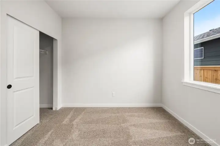 Main level bedroom. Photos of a previously completed home. Actual colors and finishes may vary. See site agent for details.