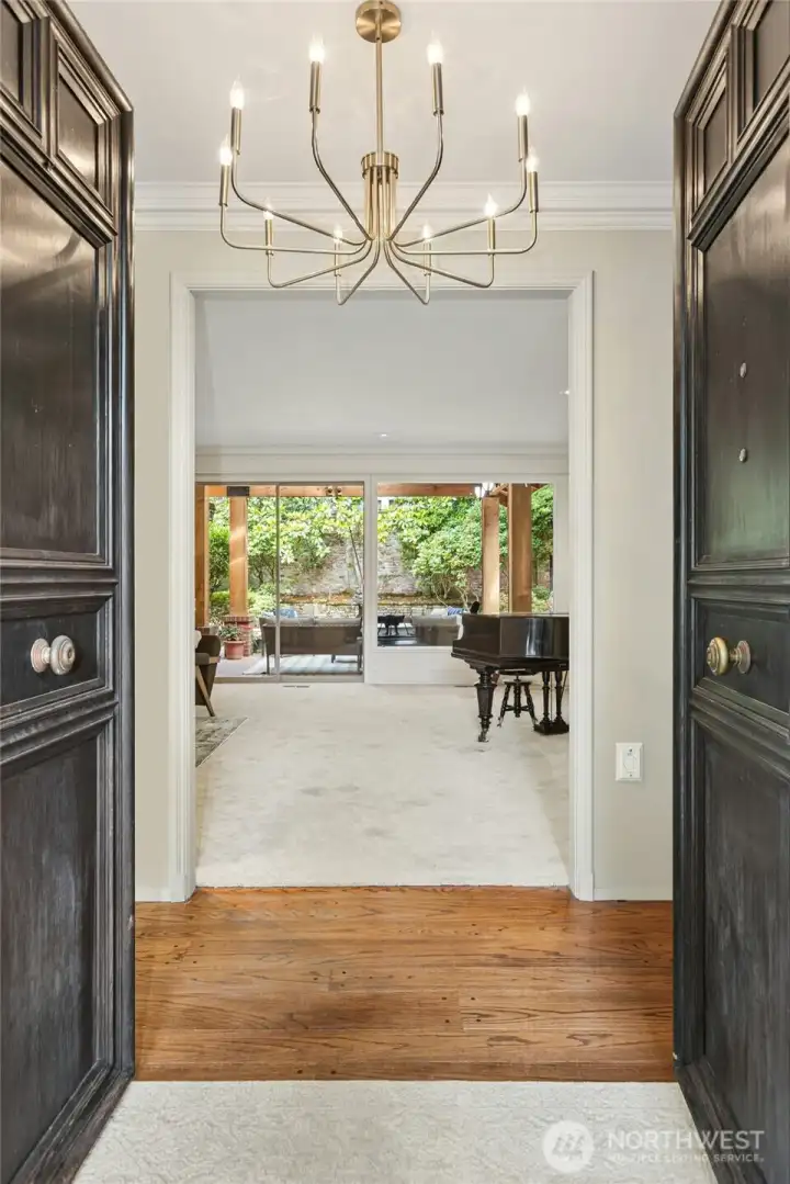 Distressed double doors with center knobs open into the entry and Formal living room.