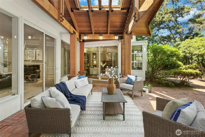 Lodge-like covered patio gives a high-end feel with black fixtures and large beams and posts.  Skylights also allow in natural light while protecting you from the elements while you use this outdoor living space.
