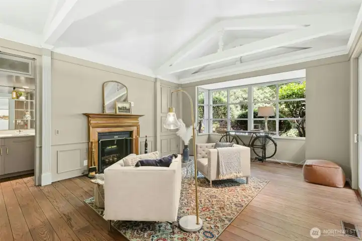 Library / den offers vaulted ceilings and a lot of natural light.  A 2nd propane fueled fireplace and a "hidden wet bar" behind paneled doors (open here) to the left.