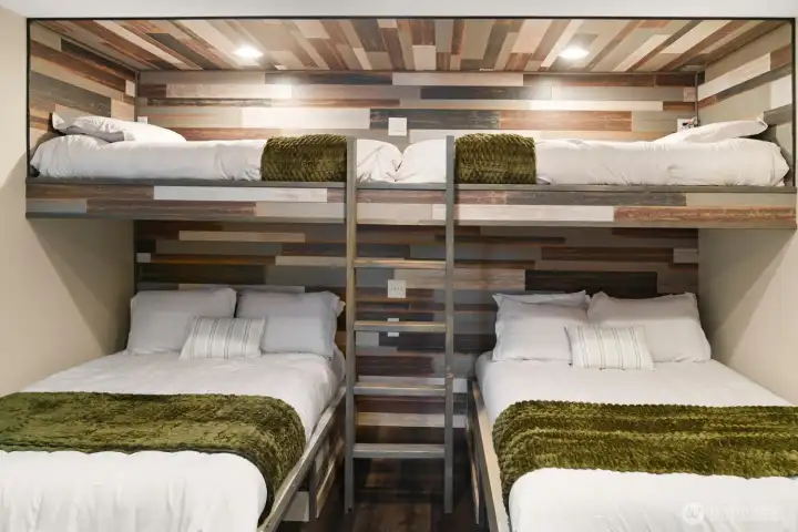 Custom-built sleeping accommodations make the most of the space, combining two queen beds with twin bunks above for a layout that's both practical and inviting. Custom-built sleeping accommodations make the most of the space, combining two queen beds with twin bunks above for a layout that's both practical and inviting.