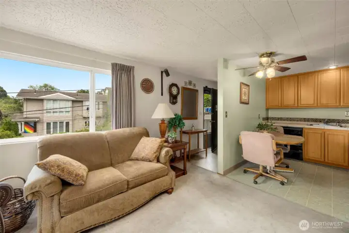 Bright living room space featuring a large picture window and carpeted floors. Bright living room space featuring a large picture window and carpeted floors.