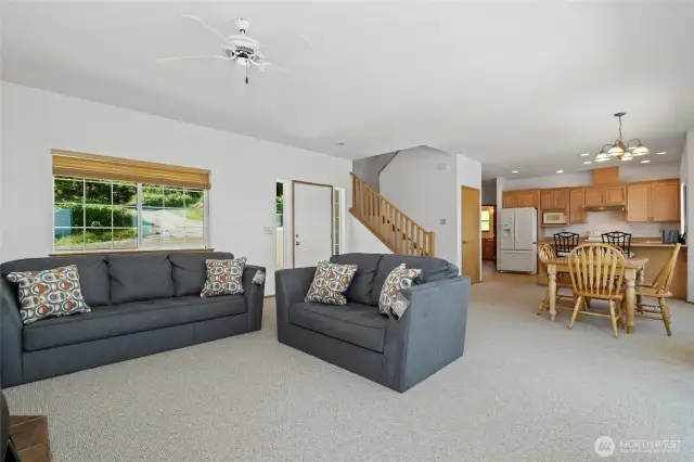 Open concept living area has high ceilings, lots of natural light & a wall of windows to a gorgeous water & mountain view. Main floor bedroom & laundry. Stairs lead to 2 bedrooms & a full bath.