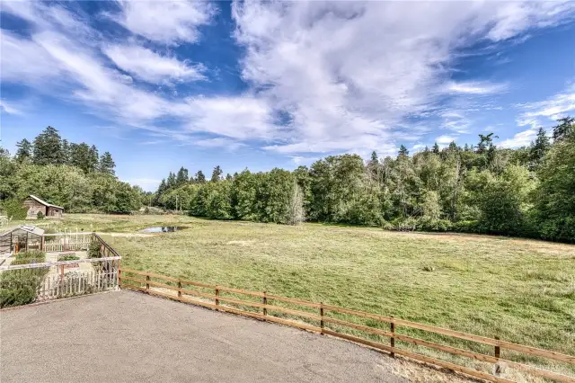 Pasture views from the back deck. The raised bed fenced garden is on the left.