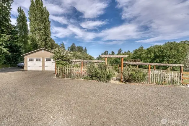 The detached two car garage with shop space has new siding, windows and roof, you will love the big beautiful, fenced garden on the right.