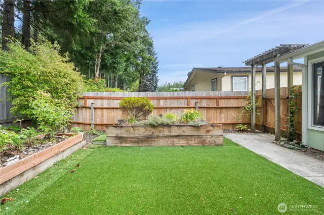 Easy care backyard with raised beds and an arbor. Backyard is fully fenced.