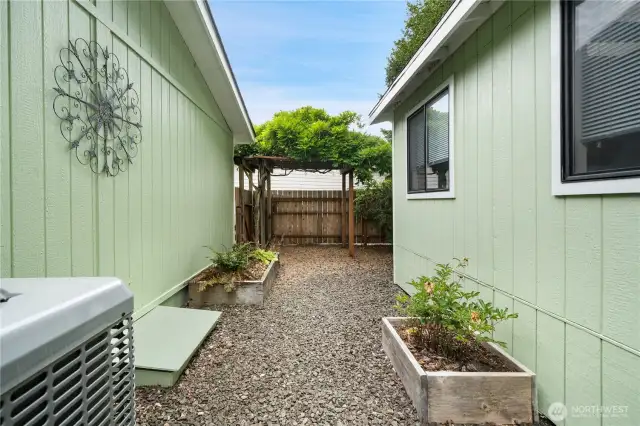Walkway between home and storage building, a second arbor over the gate on the main entrance side of the house