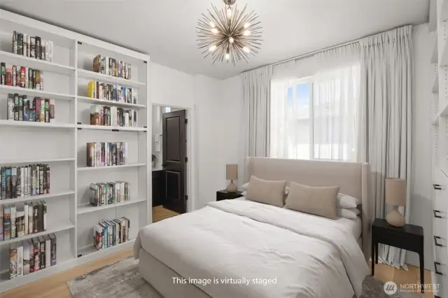 Virtually staged 3rd floor bedroom, shows Queen bed comfortably fitting in layout with wall shelving.