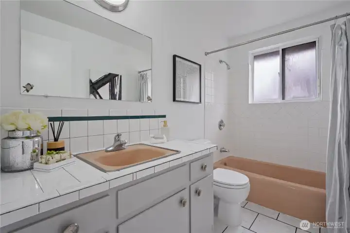 Full bathroom with tiled countertops and ceramic tiled flooring.