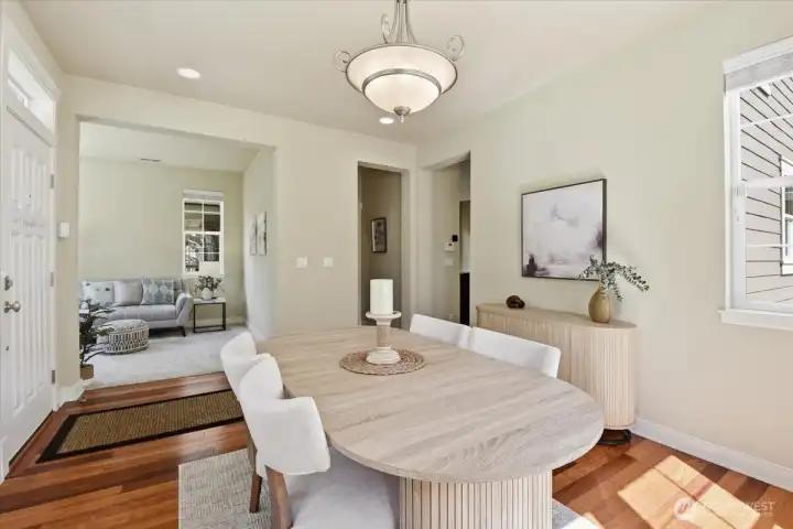 Open dining room with modern lighting, generous natural light, and an easy connection to the entry and main living areas.
