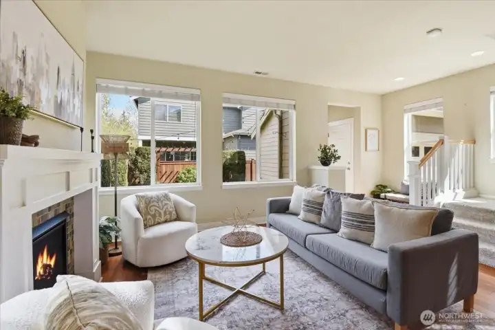 Family room filled with natural light from multiple windows, featuring a cozy fireplace and open layout in this Mill Creek home.