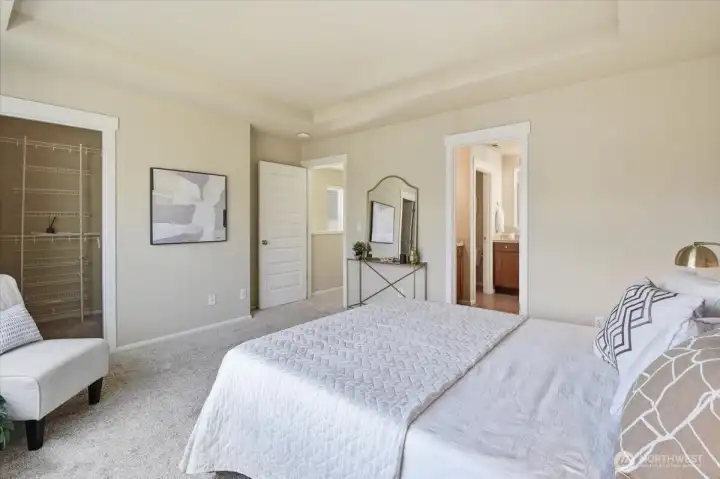 Primary suite with generous proportions, calming neutral finishes, and direct access to the ensuite bath and walk-in closet.