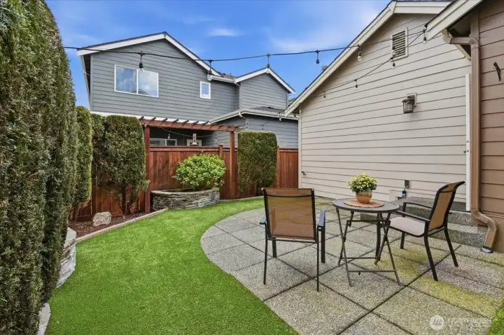 Private fenced yard with patio seating area and low-maintenance landscaping, ideal for summer dinners and relaxed weekends.