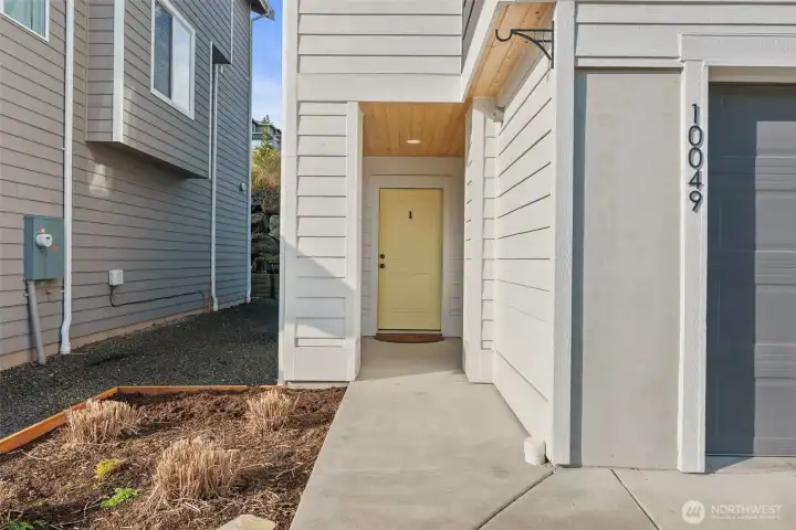 Welcoming covered entry with clean architectural lines and a warm, inviting first impression.