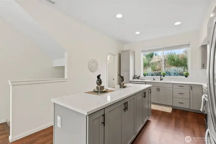 Stylish kitchen featuring a large center island, quartz countertops, and abundant cabinetry.