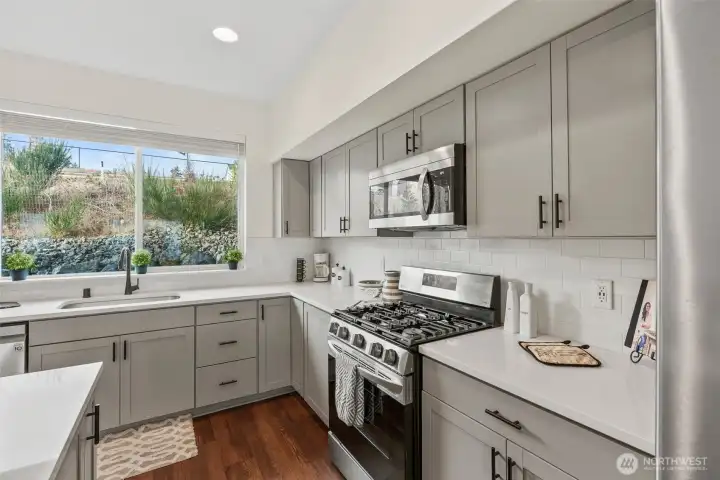Stylish kitchen featuring quartz countertops, stainless steel appliances, subway tile backsplash, and ample cabinetry.