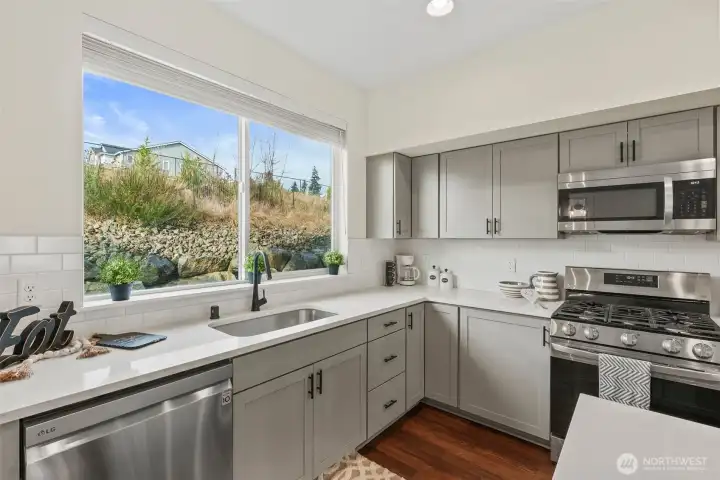 Large window over the sink brings in natural light and offers a pleasant outdoor view.