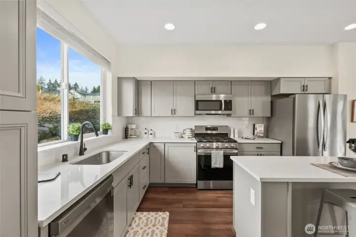 Quartz counters, subway tile backsplash, and stainless steel appliances create a clean, modern look