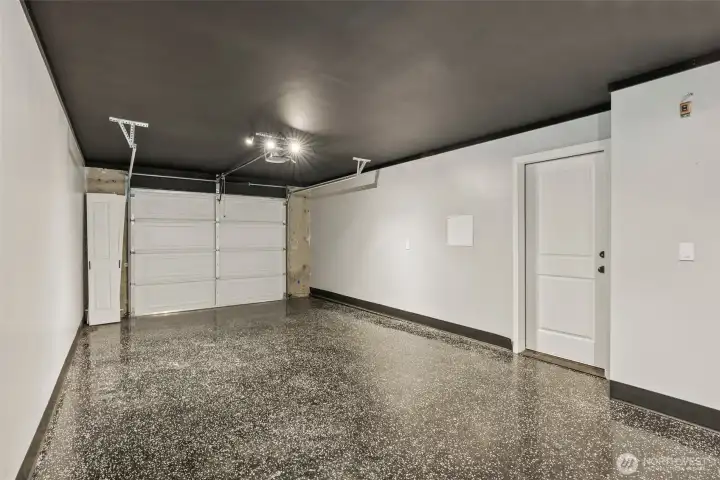 Spacious two-car garage with durable epoxy flooring and ample storage potential.