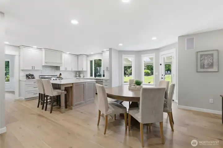 Spacious eating nook overlooks the private backyard through expansive windows and glass doors, creating the perfect setting for everyday living and entertaining. Thoughtful finishes and a bright, modern palette make this space both elegant and inviting.