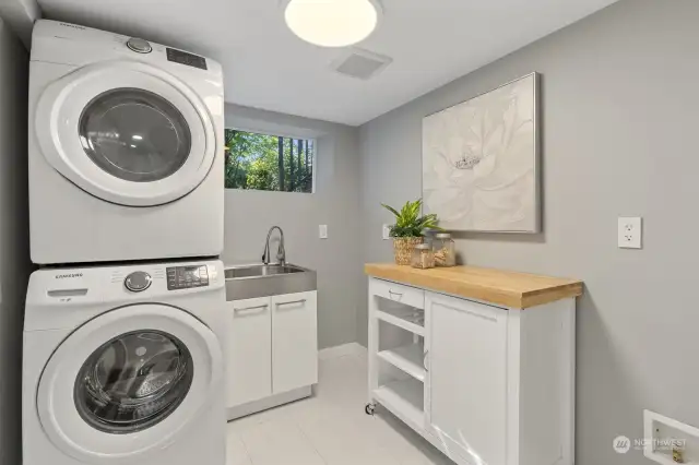 Spacious laundry room on the lower level with a utility sink and storage space.