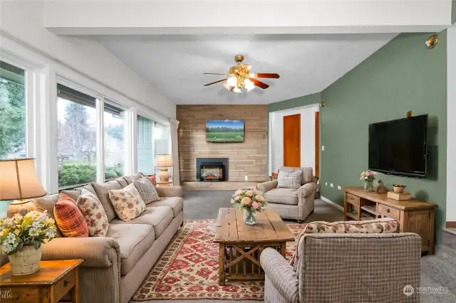 Sit back and relax in your inviting living room, featuring newer carpet and large windows that fill the space with natural sunlight while offering picturesque views of Barnes Lake.