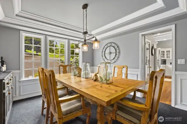 Dining room has a tray ceiling setting the mood for dinner parties.