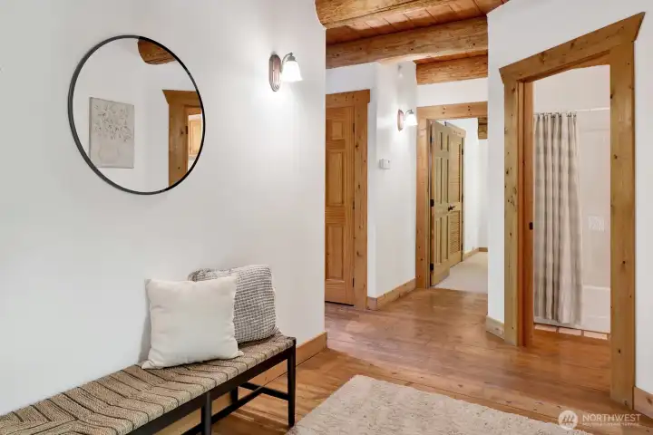 Wood flooring is accented by the white walls