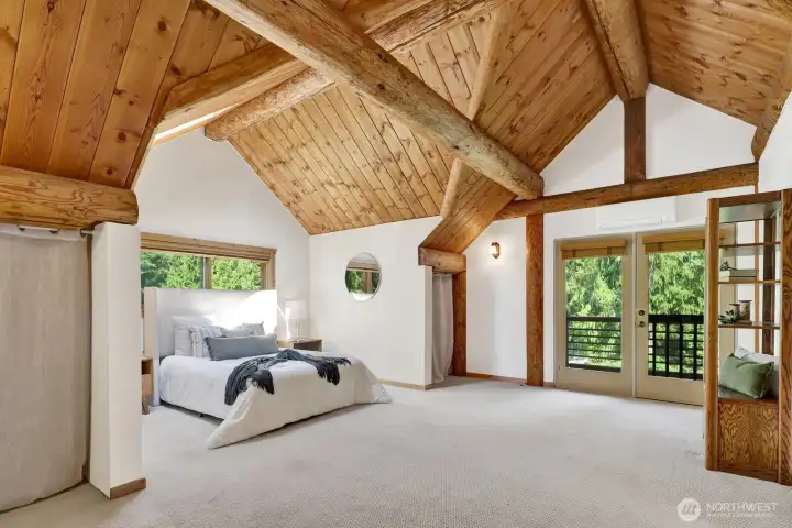 The stunning primary suite features vaulted ceilings, a private balcony, lots of storage, and a mini-split system for air conditioning and efficient heat
