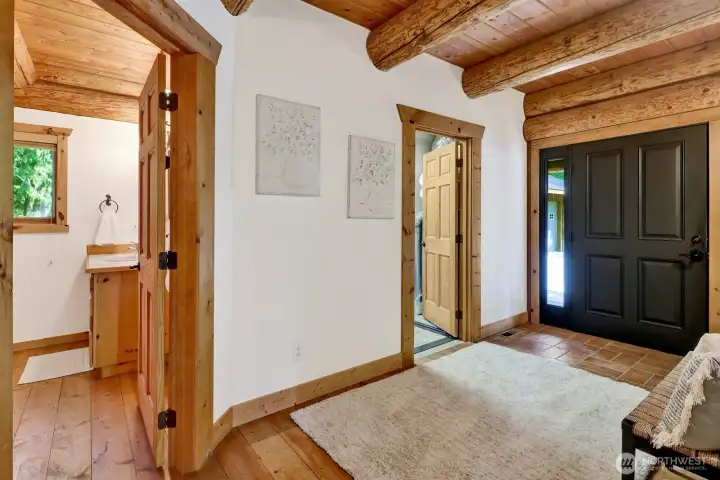 A view of the entryway with the main floor bathroom and the utility room