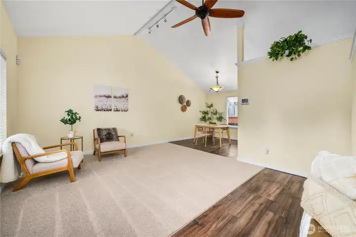 From here you can see how the living room connects effortlessly to the dining space. Vaulted ceilings and an overhead ceiling fan add character and comfort, creating an inviting central hub of the home.