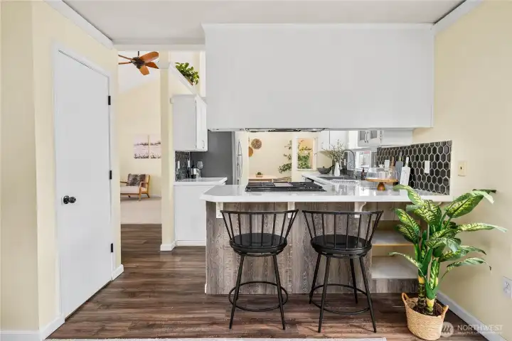 From this view, the peninsula with breakfast bar seating connects the kitchen seamlessly to the living and dining spaces. The combination of modern updates and open flow makes this kitchen the true heart of the home.