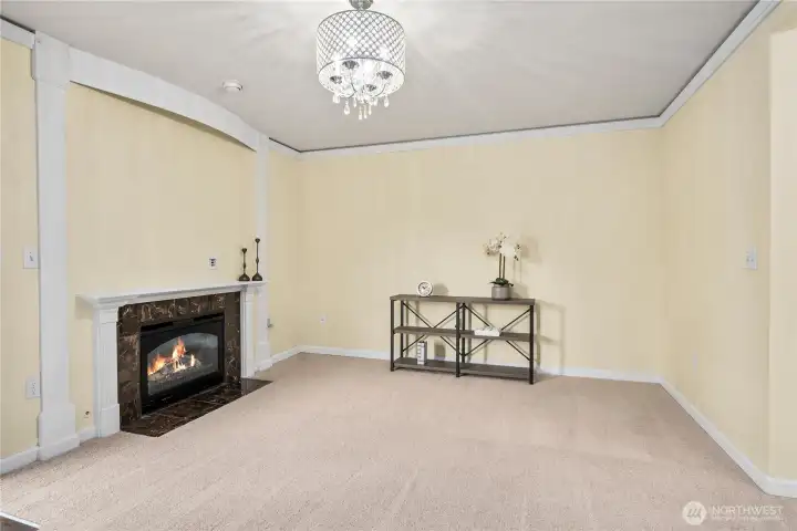 A closer view of the family room shows off the fireplace detail and generous wall space, ideal for entertainment or display. The updated ceiling fixture adds a touch of elegance.