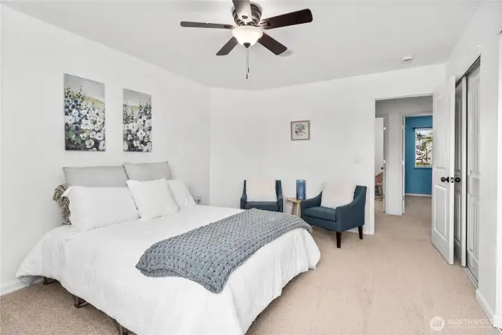 From this angle, the primary bedroom showcases its generous layout and easy access to the adjoining hallway. Double-door closets provide ample storage while maintaining a clean, streamlined look.