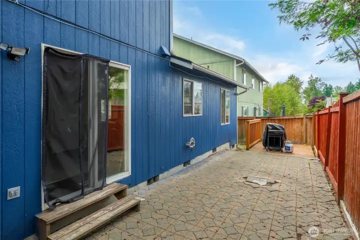 Another angle of the paver patio highlights its generous space for seating or entertaining. Direct access from the sliding glass door makes indoor-to-outdoor living seamless.