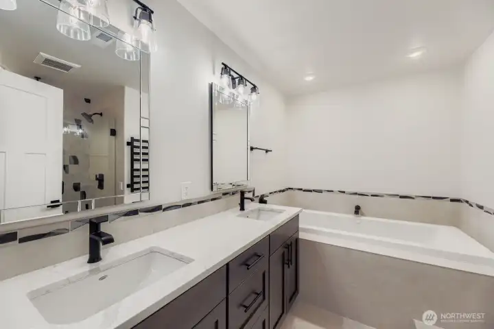Main-floor primary suite bath with jetted tub, rain shower & heated towel rack