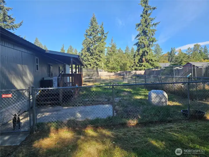 Covered back deck perfect for BBQ. Also, a fenced in dog run area.