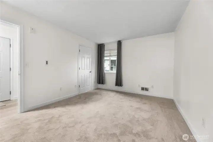 Main bedroom features brand-new carpet, fresh white paint, walk-in closet, & additional access door to the bathroom. Virtual staging to showcase potential furniture placement.