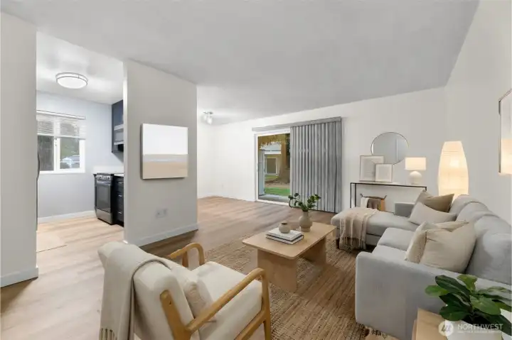 Ground-floor corner unit living room with brand-new LVP flooring, fresh white paint, and virtual staging to show furniture layout.