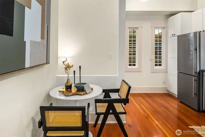 Eating nook in kitchen with stairs to lower level behind half wall.