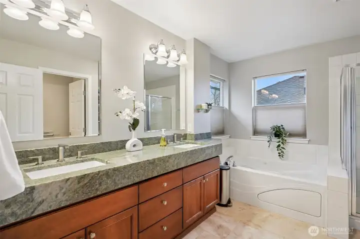 5-piece ensuite bath with custom raised slab stone counters and travertine tile floors.