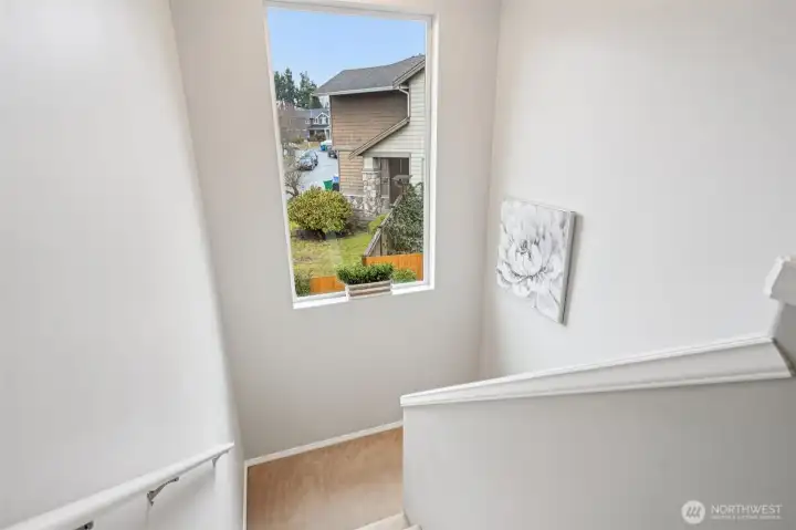 Staircase with large window flooding the home with light.