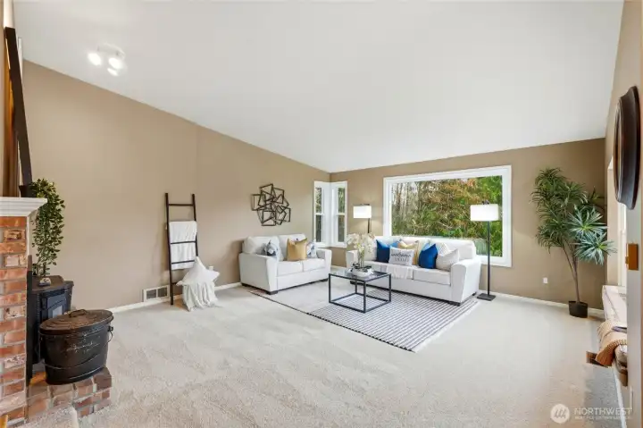 The inviting living room is filled with natural light and anchored by a cozy fireplace that makes the space feel instantly welcoming.