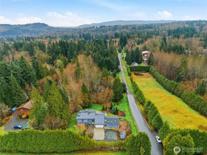 Set on 1.22 acres surrounded by lush trees and open green space, the property feels peaceful, secluded, and immersed in nature.