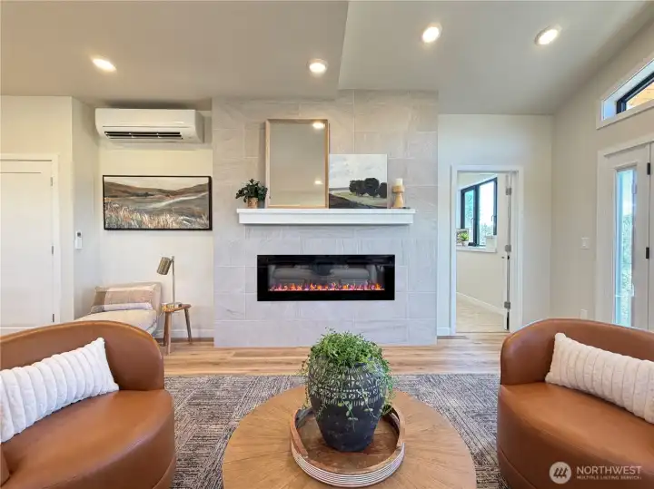 Custom designed tiled fireplace with mantel and electric LED fireplace with multiple heat and light settings.