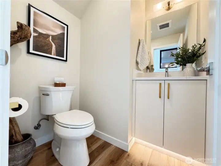 Main floor powder room tucked around the corner from main living spaces. Motion actived under cab lighting