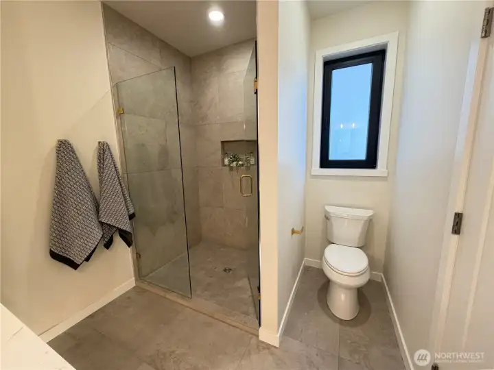 Custom designed fully tiled shower with glass enclosure.