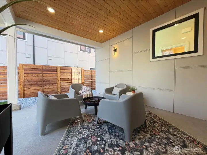 Charming outdoor covered patio with wood paneled ceiling, lighting and direct access to kitchen and fully fenced backyard.